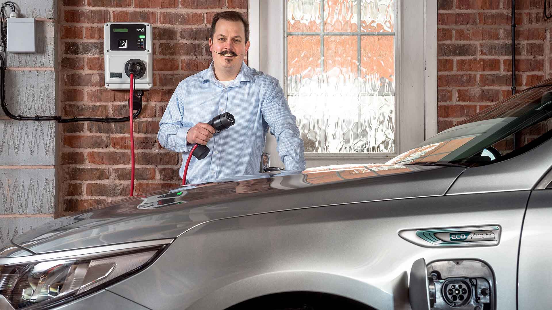 Electric car owner unplugging their vehicle