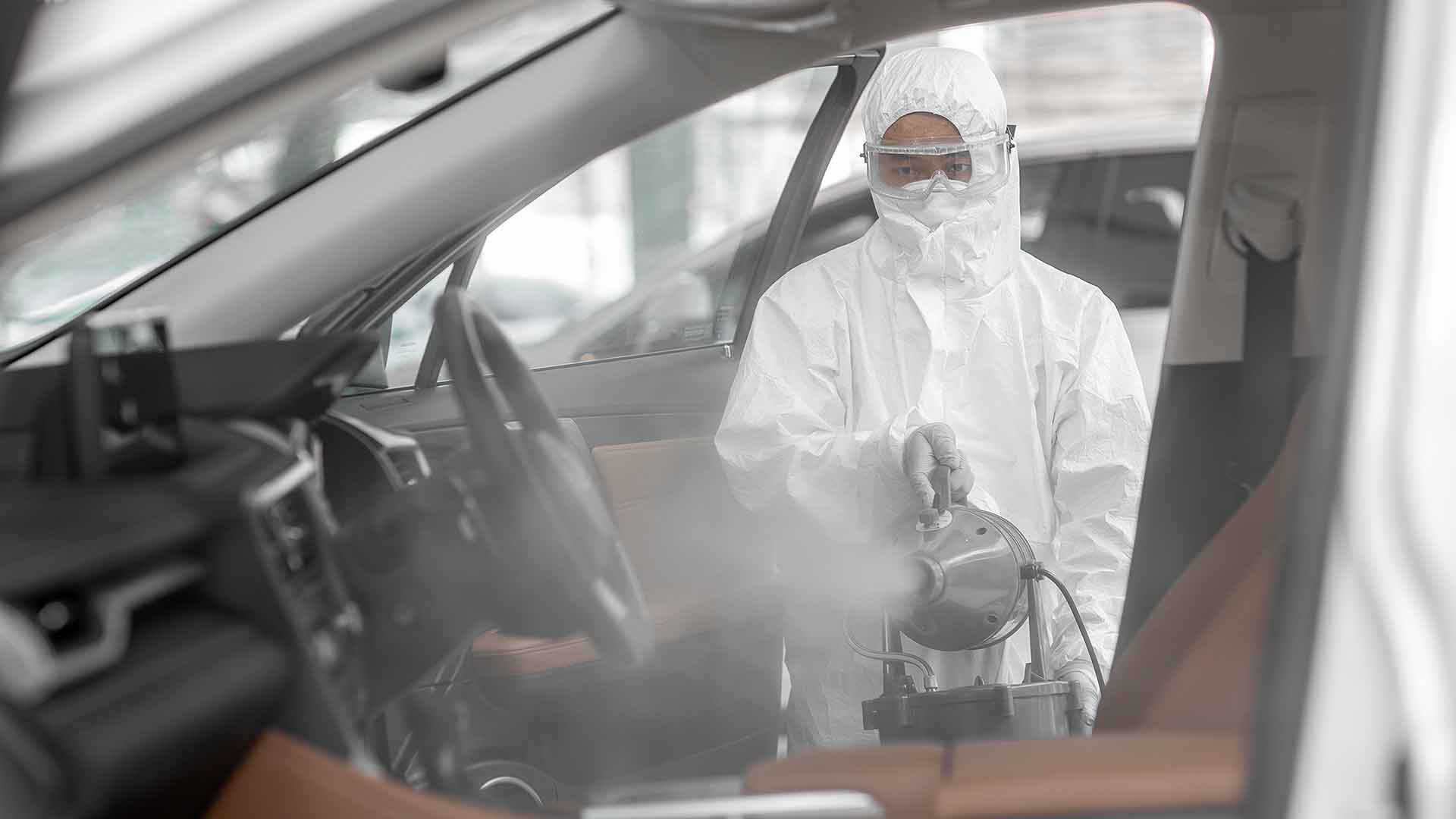 Technician spraying an anti-baterial mist into a vehicle