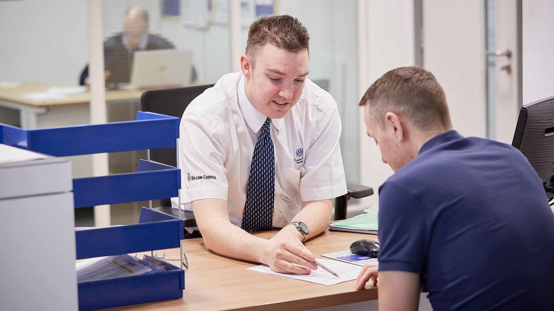 Customer and dealer checking a finance agreement